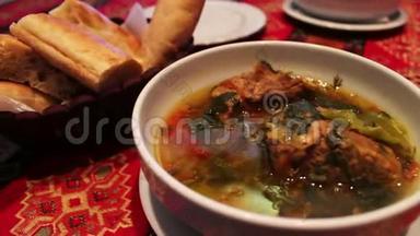 餐厅提供美味的阿塞拜疆国民羊肉汤。 面包背景上白色盘子里的肉